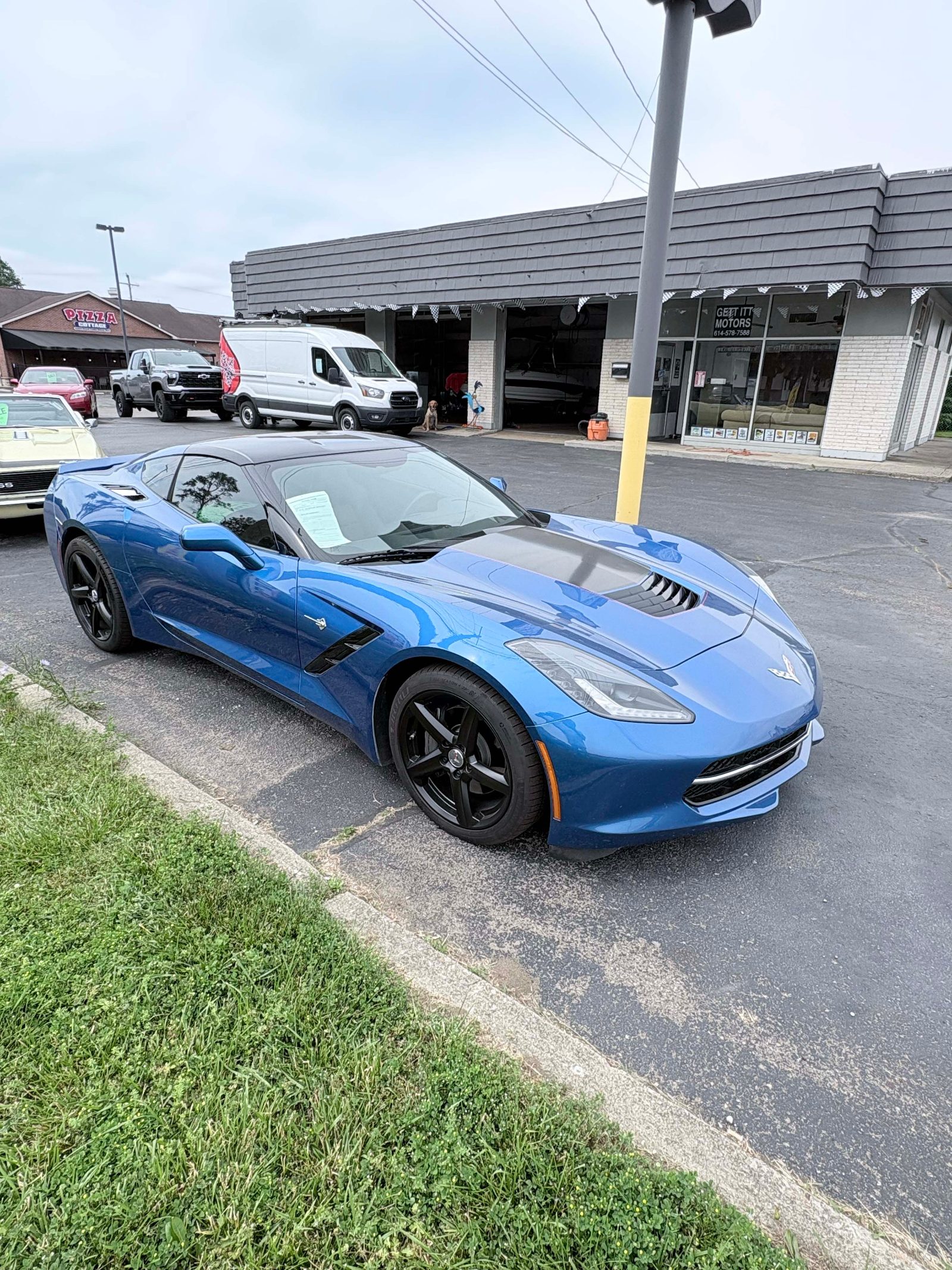 Blue C7 Chevrolet Corvette Stingray front three-quarter at the dealership